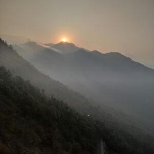 Serene sunset with mist over mountains in Wayanad, India.