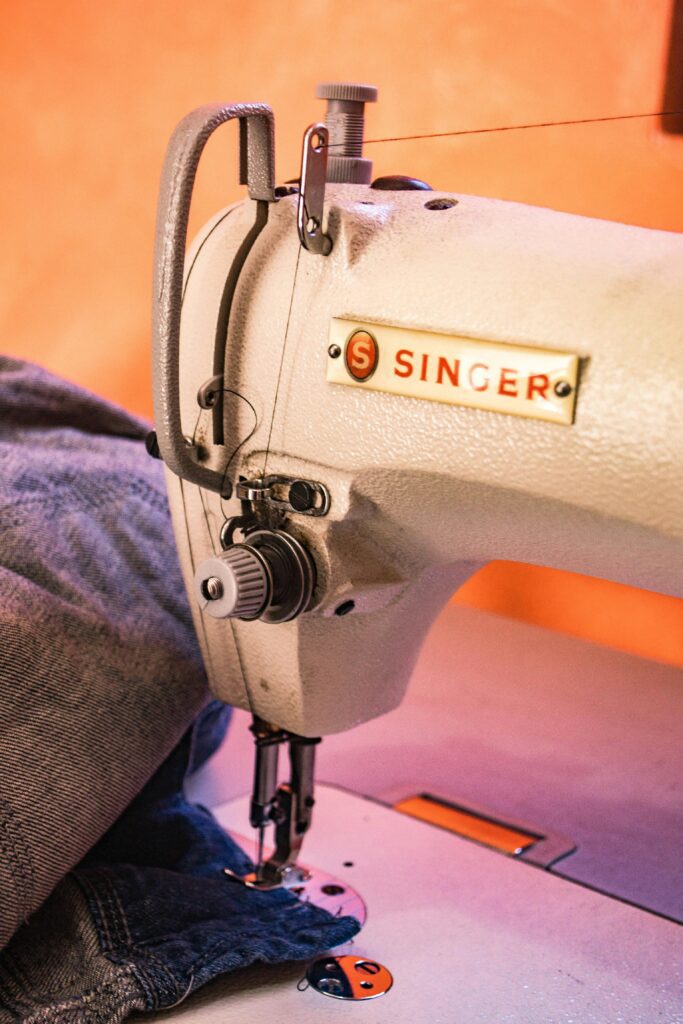 Detailed view of a Singer sewing machine working on denim fabric with precision.